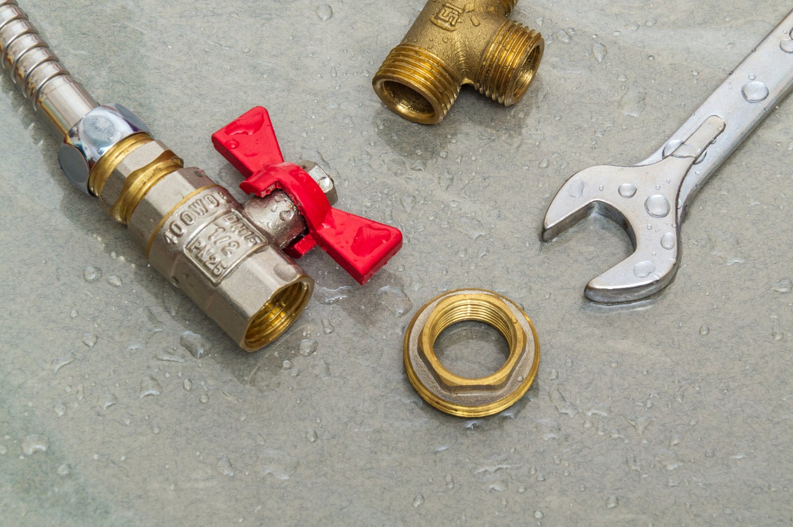 Plumbing faucet and wrench in water drops during equipment repair during an accident